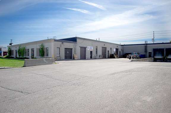A large industrial building with a parking lot in front.