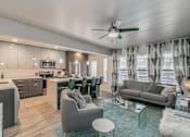 Thumbnail 2 of 30 - Modern open-concept living room with ceiling fan and wood-style floors at Reserve on Abrams Dallas