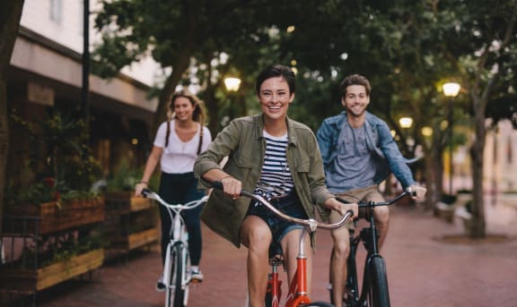 a group of people riding bikes down a street