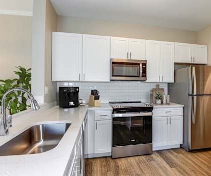 a kitchen with white cabinets and stainless steel appliances at Bay Breeze Villas, Fort Myers, Florida