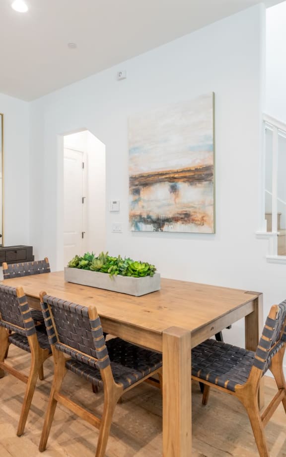 A dining room with a wooden table and chairs.at Crocker Village – Single Family Homes, California, 95818