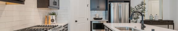 A modern kitchen with dark brown cabinets and white countertops.at Crocker Village – Single Family Homes, Sacramento, CA 95818