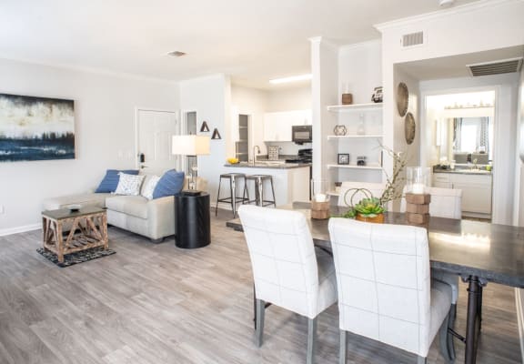 a living and dining room area with white walls and hardwood floors