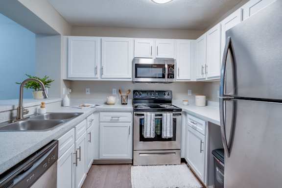 a kitchen with stainless steel appliances and white cabinets