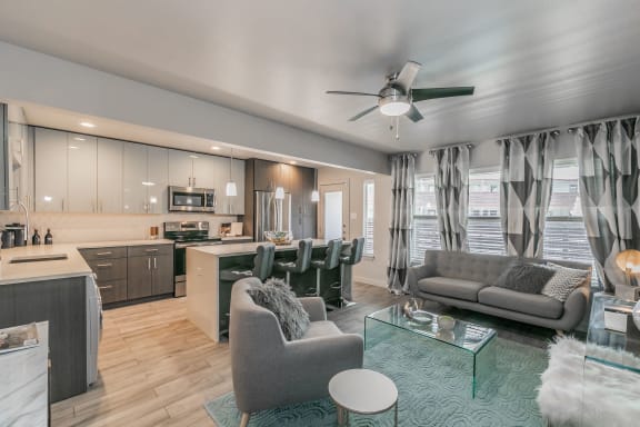 Modern open-concept living room with ceiling fan and wood-style floors at Reserve on Abrams Dallas