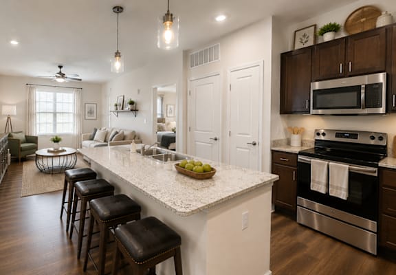 Modern kitchen with granite-style countertops, stainless steel appliances, and bar seating at Auberge of Tyler.