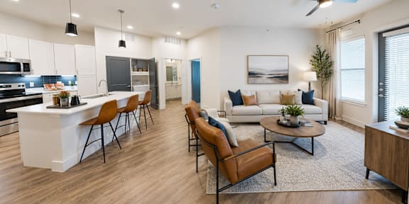 Open-concept living room and kitchen with breakfast bar, natural light, and modern finishes at The Mill Old Town Apartments.