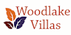The image is a logo for Woodlake Villas with a black background and colored leaves.