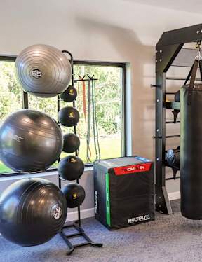 A fitness center with a punching bag, weights, and exercise equipment.