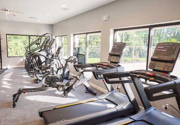 An expansive fitness center featuring state-of-the-art cardio equipment and large windows.