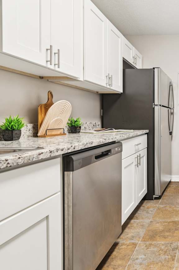 A kitchen with black appliances and white cabinets at Esplanade at City Park, New Orleans, 70119