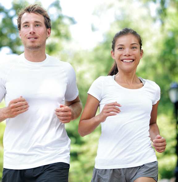 A man and a woman are jogging in a park.