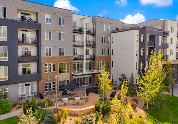 an aerial view of an apartment building with trees and a courtyard