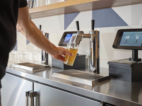 a person filling a glass of beer at a brewery