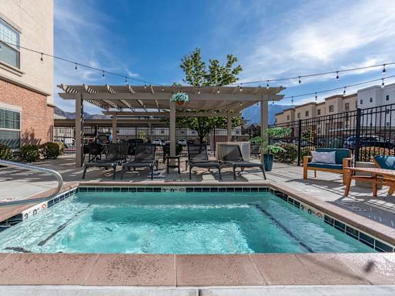 A pool area with a canopy and chairs.