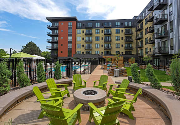 Be Social phrase with background of outdoor fire pit with green chairs around fire pit at Be @ Axon Green, Minneapolis, MN