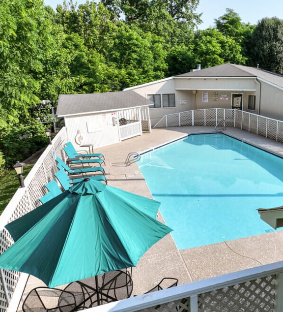 a swimming pool with chairs and a railing on the side of it