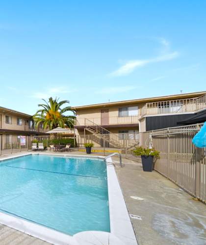 A pool in a courtyard surrounded by apartment buildings.
