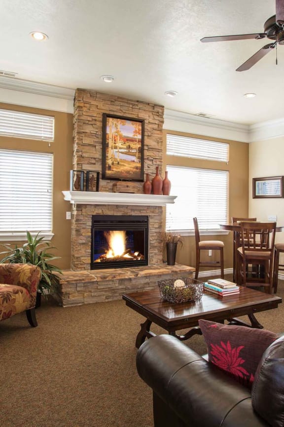 a living room with a fireplace and leather furniture  at Oakstone Apartments, Utah, 84015