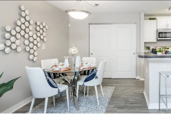 A modern kitchen with a dining table set for two.