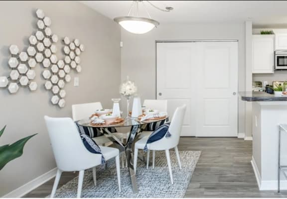 A modern kitchen with a dining table set for two.