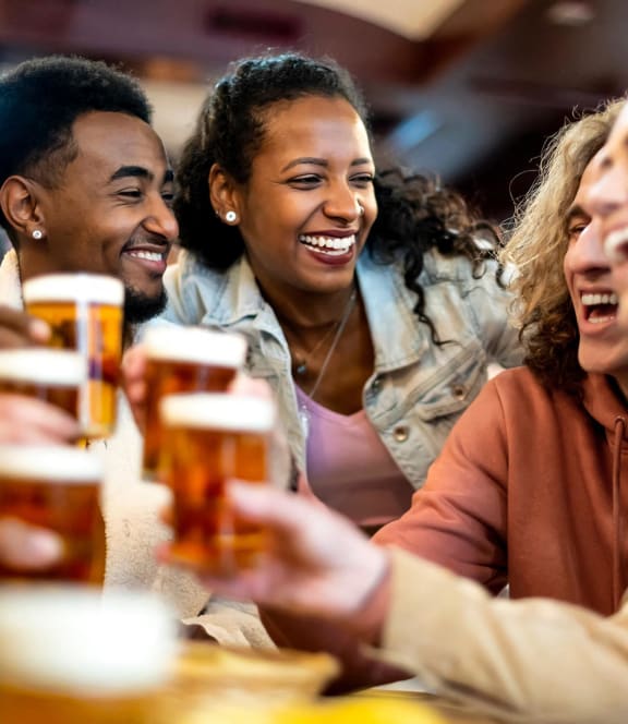 a group of people sitting at a table laughing and drinking beer at Colony Townhomes, Raleigh, NC, 27609