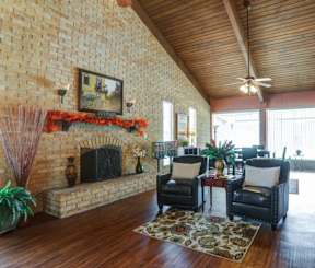 space iwth large bay windows, a brick fireplace, and hardwood floors