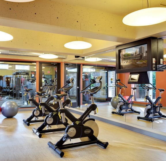 a gym with cardio equipment and a flat screen tv  at Mears Park Place, St. Paul, Minnesota