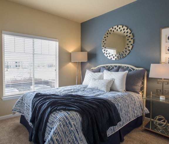 a bedroom with a bed and a mirror on the wall