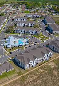 A bird's eye view of a residential area with houses and a swimming pool.
