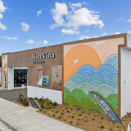 A wall with a mural of waves and a sun.