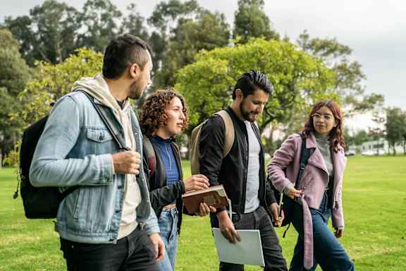 Four students walking in a park.
