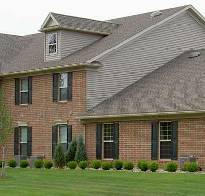 a large brick house with asphalt shingles on the roof