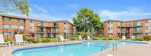 A pool surrounded by apartment buildings with a no swimming sign on the ground.