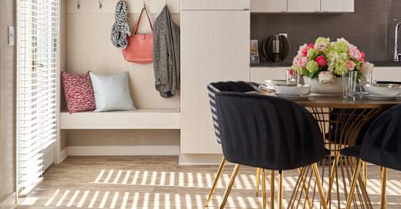 A kitchen with a table and chairs and a bench with pillows.