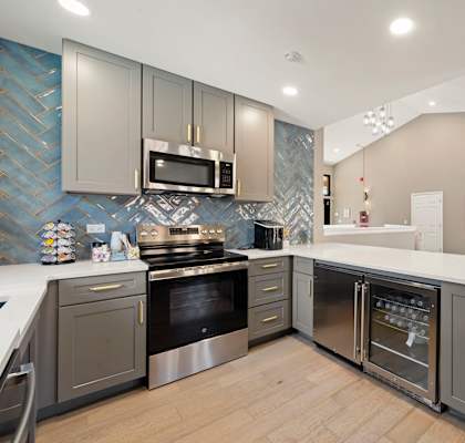A modern kitchen with a stove top oven and a microwave above it.