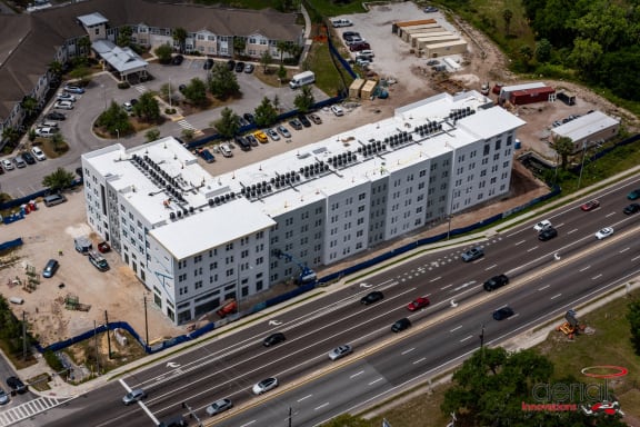 an aerial view of a large white building next to a highway