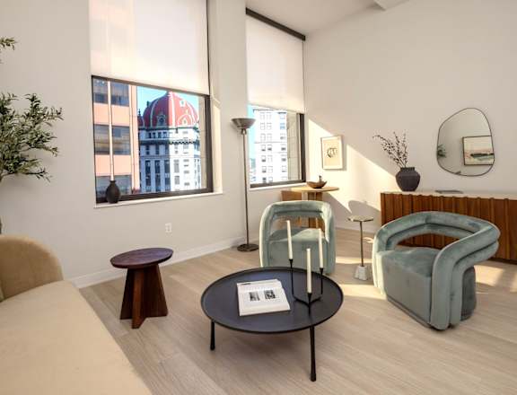 A living room with a round table and a green chair.