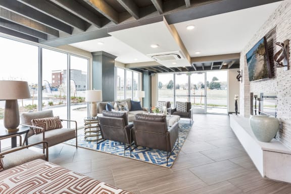 Westwood Green Apartments Clubhouse Lounge with oversized furniture, fireplace, and tv