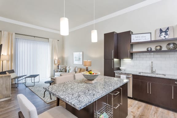 Westwood Green Apartments open floorplan Living Room and Kitchen with large island, stainless appliances, and quartz countertops