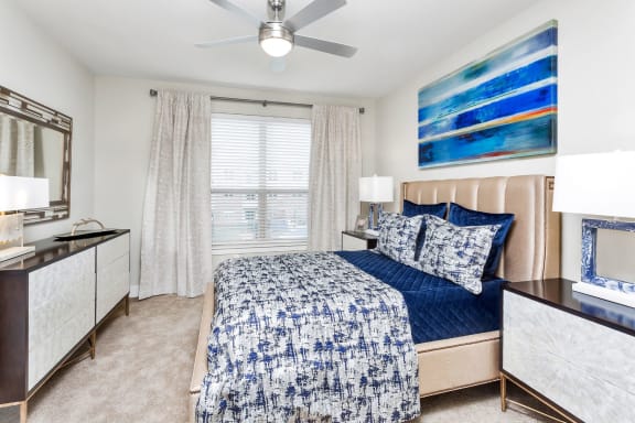Westwood Green Apartments Master bedroom with wall to wall carpet, ceiling fan and large windows