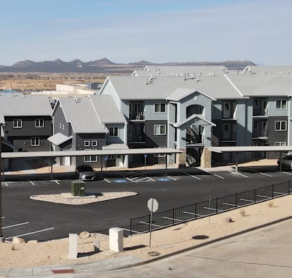 A large building complex with a parking lot in front.