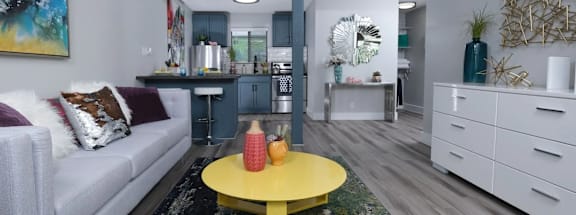 A living room with a grey couch and a yellow coffee table.