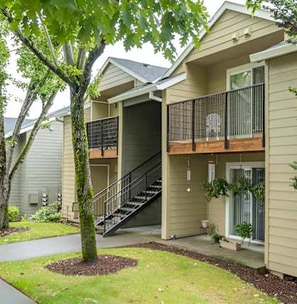 A tree is in front of a house.