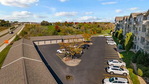 A parking lot with cars and a building in the background.
