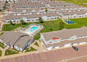 Thumbnail 3 of 10 - A swimming pool is surrounded by houses in a residential area.