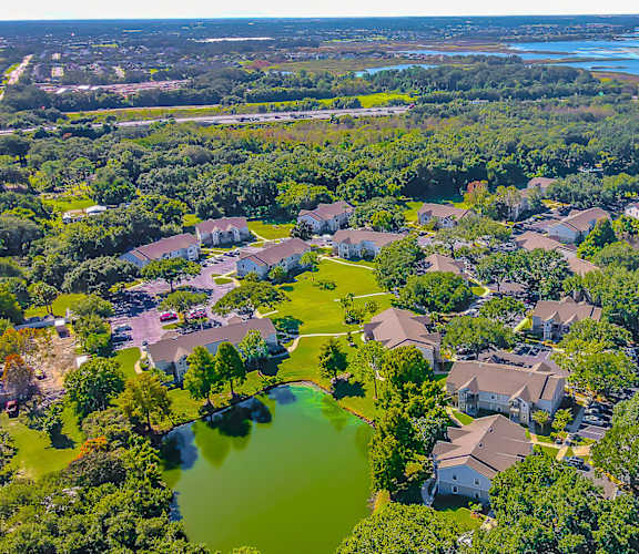 A bird's eye view of a residential area with houses and a lake.