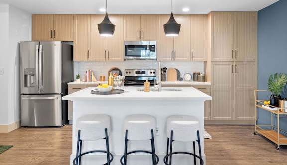 A modern kitchen with a white island and stainless steel appliances. at Lucie at Tradition Apartments, Port St. Lucie, FL, 34987
