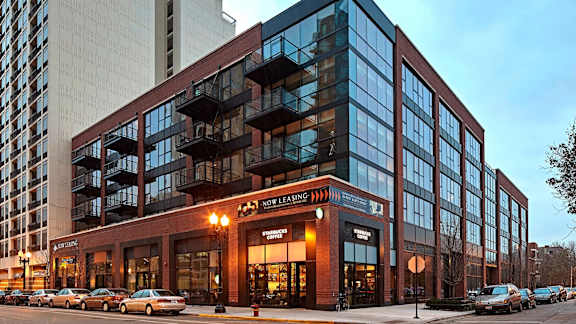 A modern building with a glass facade and a red brick exterior.