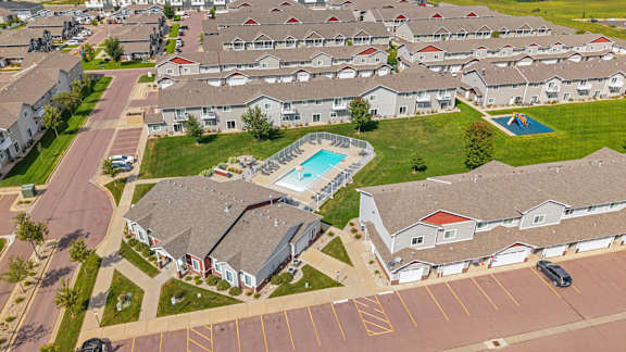 A swimming pool is surrounded by houses in a residential area.